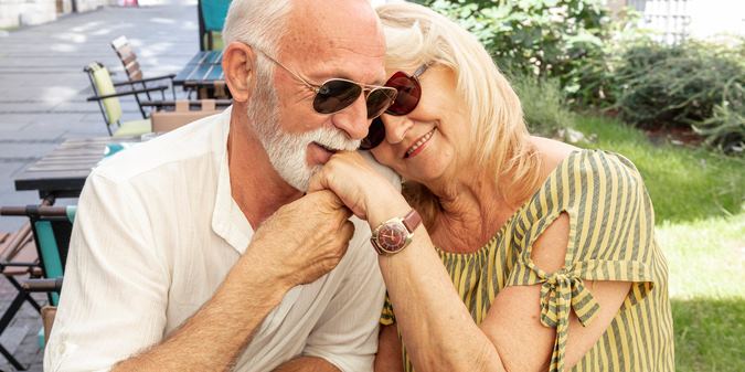 happy old man kissing ladys hand
