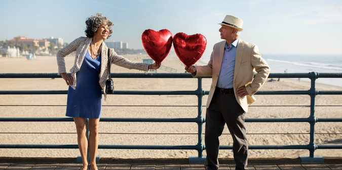 Senior couple holding heart-shaped balloons