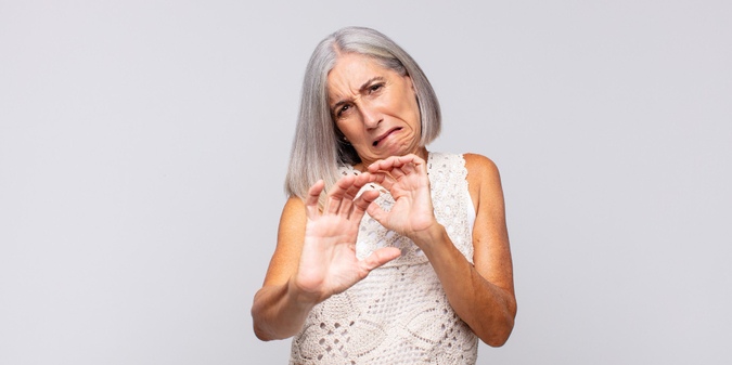 Gray haired woman feeling disgusted