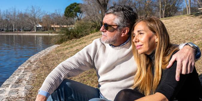 mature woman and man cuddling on riverside