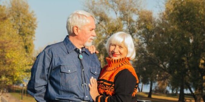 Happy elderly man and woman sitting on a bench