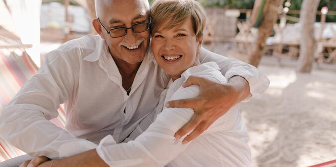 Elegant old couple sitting at home and using a laptop