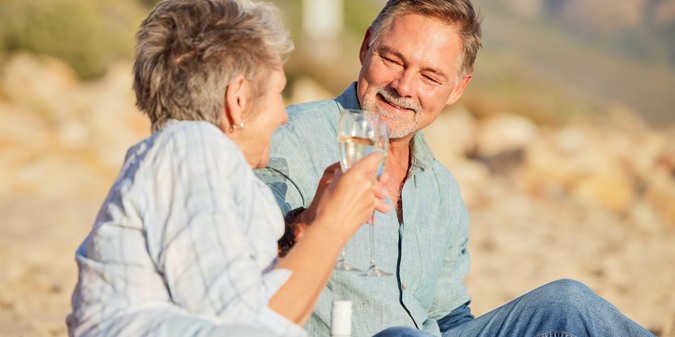 Champagne beach and love celebration of mature couple