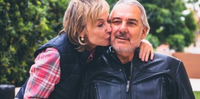 Elderly woman kissing man on cheek
