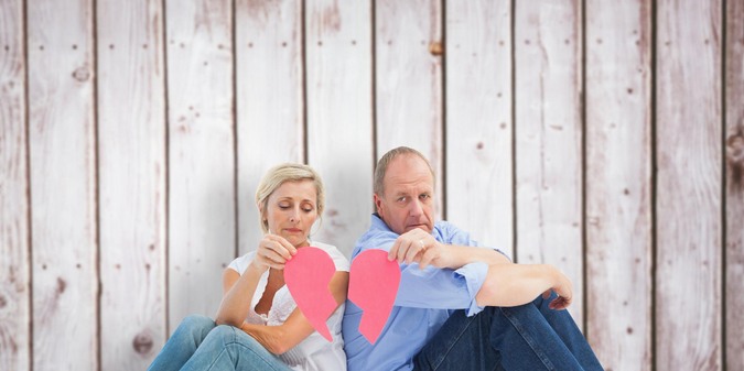 Sad mature couple holding a broken heart