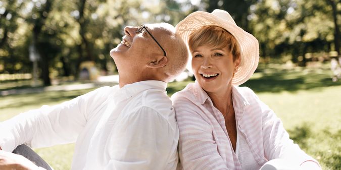 An elderly couple sits on the lawn