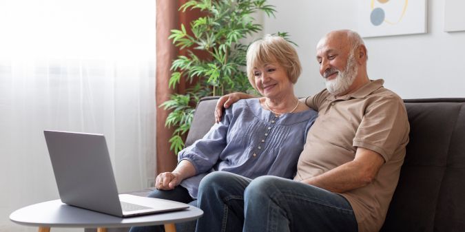 A happy senior couple enjoying a movie together, sharing laughter and quality time