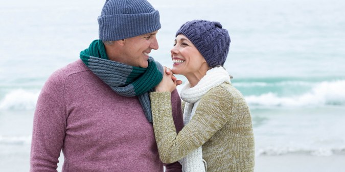 Smiling happy couple both wearing scarfs and hats