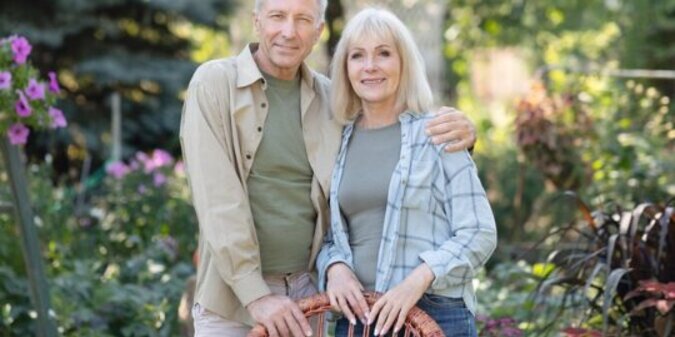Loving retired spouses embracing resting in garden