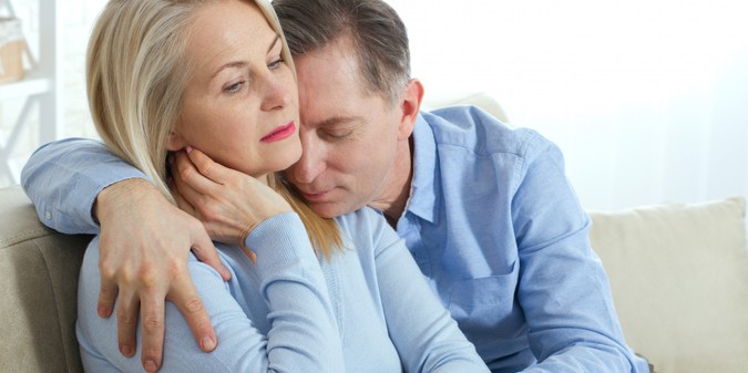 couple hugging and sitting on sofa in living room