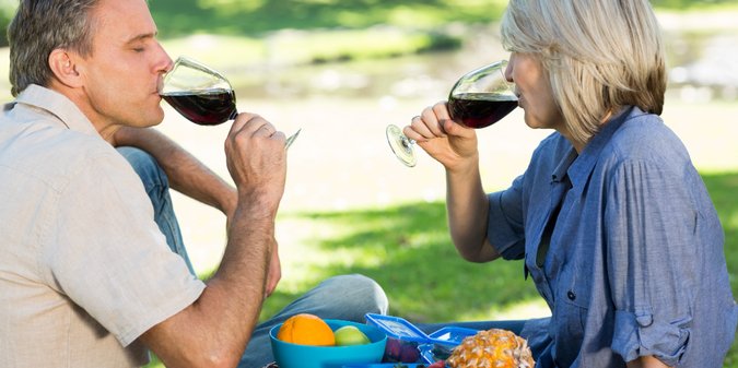 Couple drinking red wine in park
